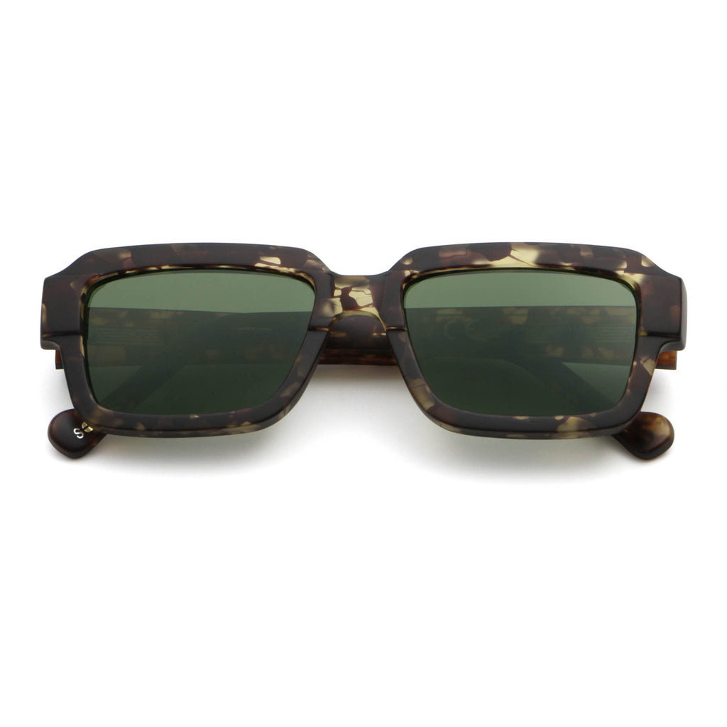 Sunglasses with tortoiseshell frame and green lenses on a white background