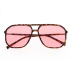 Sunglasses with tortoise print frame and pink lenses on a white background